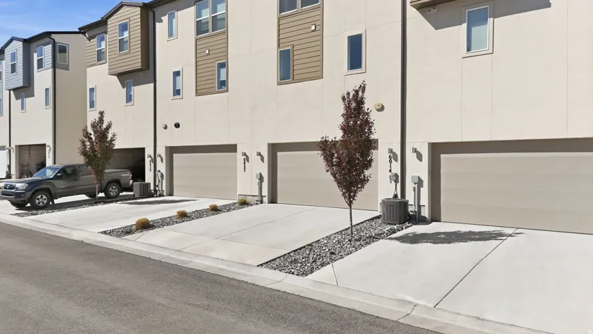 View of front of house featuring an attached garage, stucco siding, and driveway