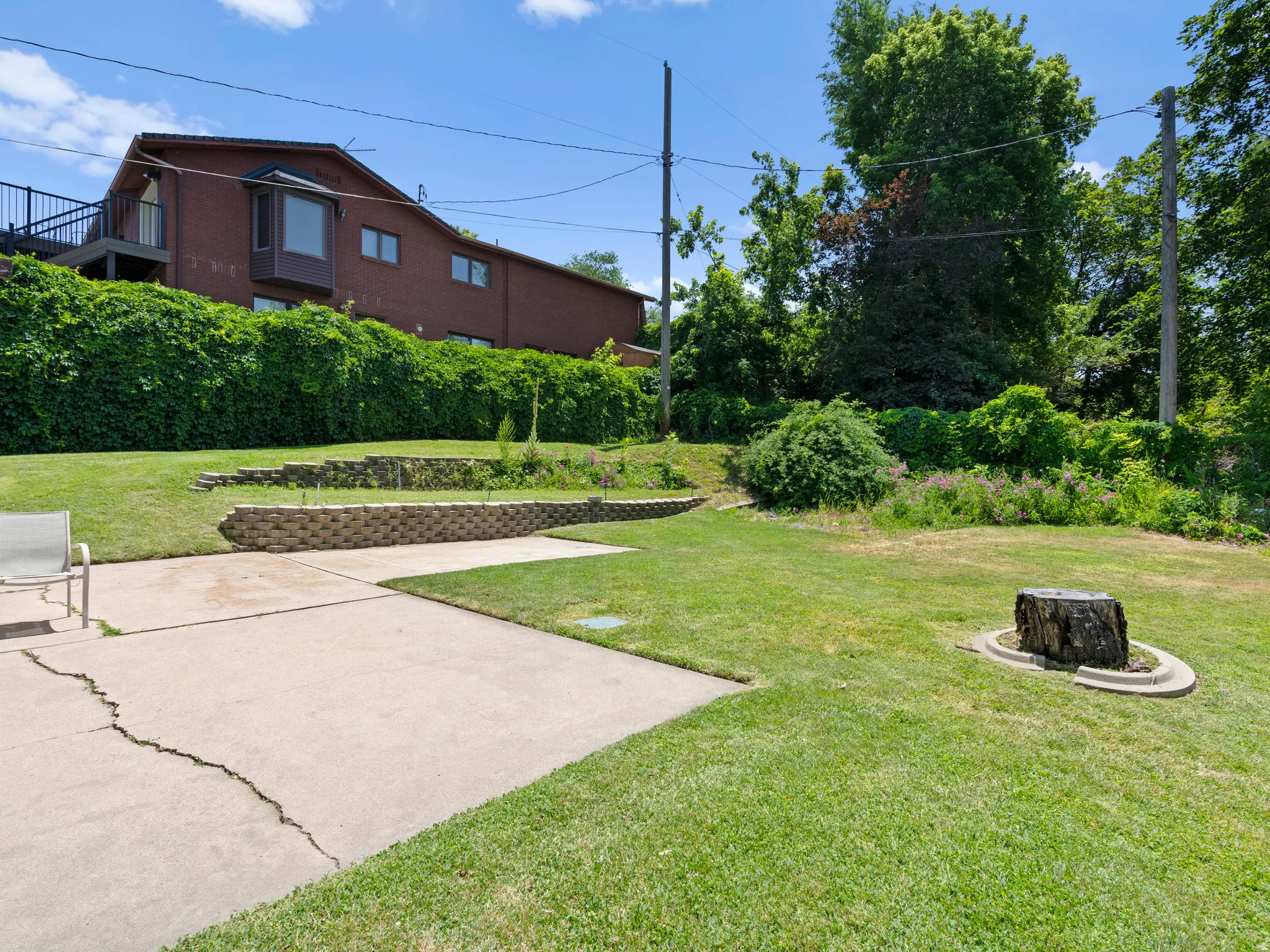 View of green lawn featuring a fire pit and a patio
