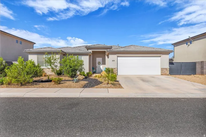 View of front of home featuring stucco siding, an attached garage, stone siding, and concrete driveway