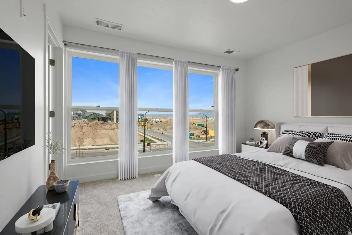 Bedroom with light carpet and a water view