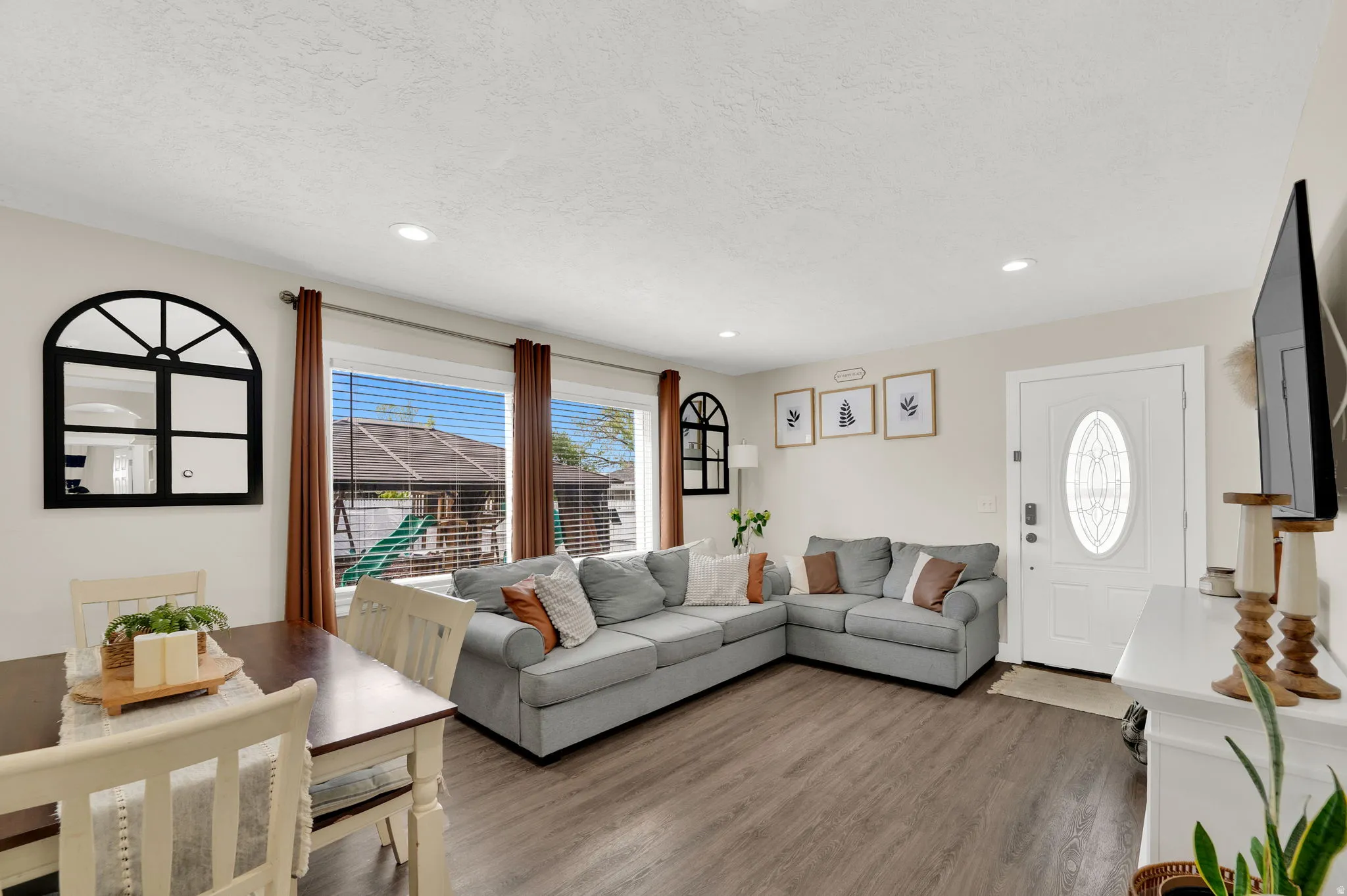 Living room with plenty of natural light, dark wood finished floors, recessed lighting, and a textured ceiling
