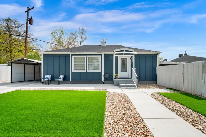 View of front of property with board and batten siding, a shingled roof, and a carport