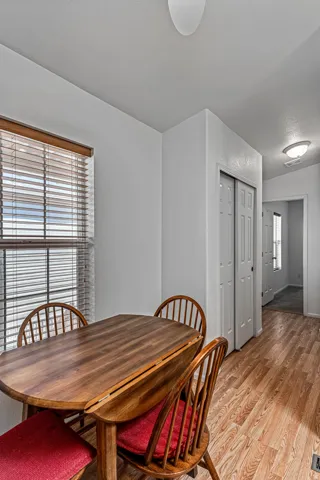 Dining area with light wood-style floors, a textured ceiling, and a textured wall