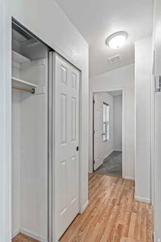 Hallway featuring a textured ceiling and light wood finished floors