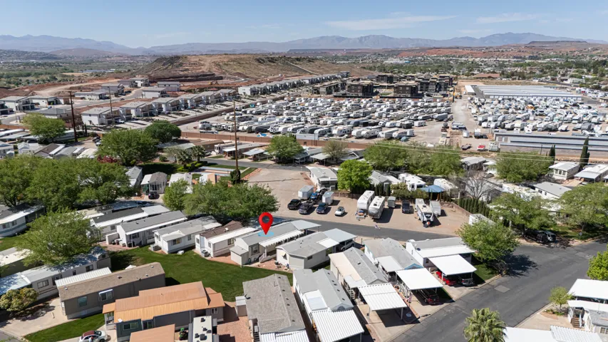 Aerial view of property and surrounding area featuring a mountain backdrop