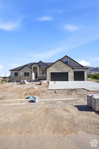 Contemporary stone and siding exterior with dark trim and a prominent two-car garage
