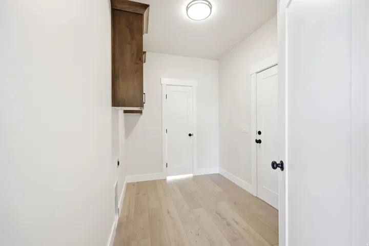 Hallway with wood-finish flooring and white baseboards