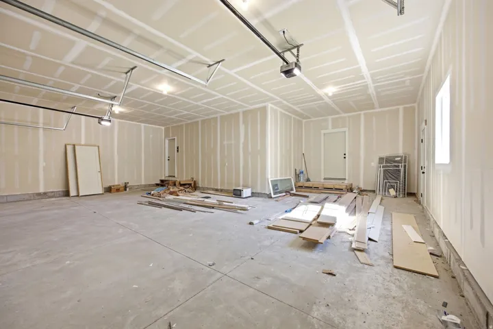 Spacious garage featuring concrete flooring and unpainted drywall