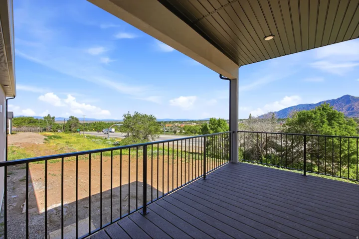 Covered outdoor deck with composite decking and black metal railings