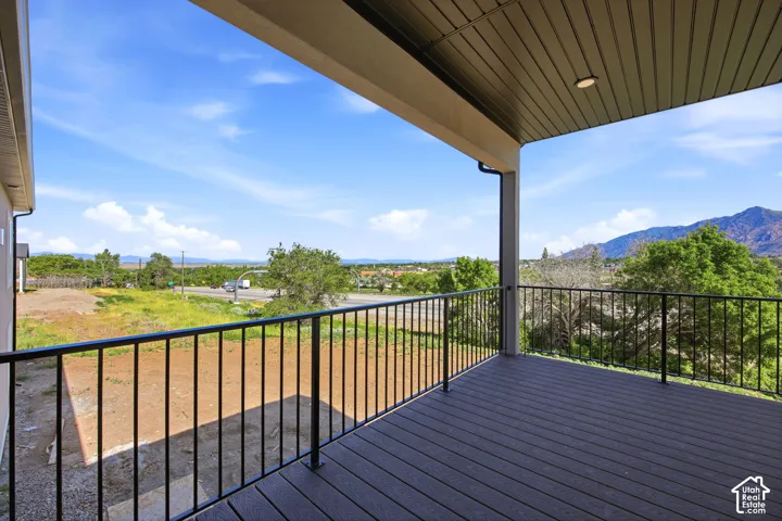 Covered outdoor deck with composite decking and black metal railings