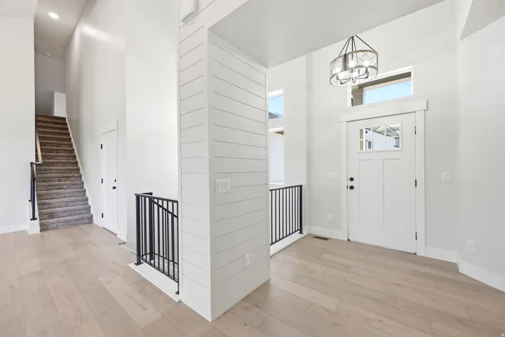 Bright entryway featuring wood-finish flooring and a contemporary chandelier