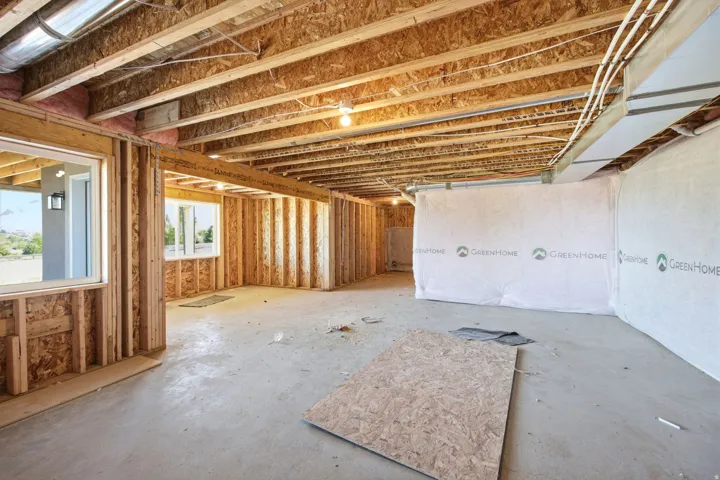 Spacious unfinished interior framing with exposed ceiling joists and concrete flooring