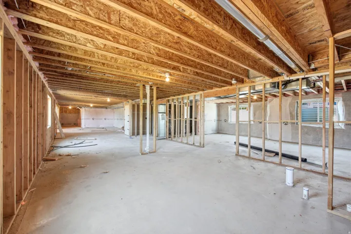 Unfinished basement space featuring substantial wood framing and exposed ceiling joists