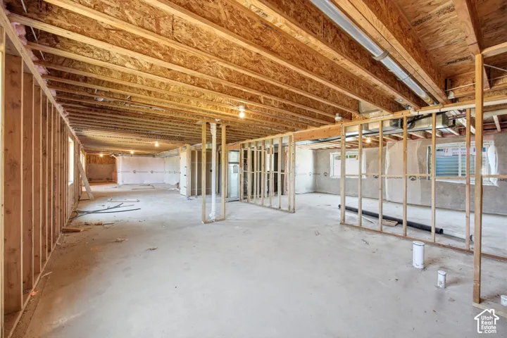 Unfinished basement space featuring substantial wood framing and exposed ceiling joists