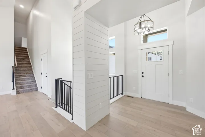 Bright entryway featuring wood-finish flooring and a contemporary chandelier