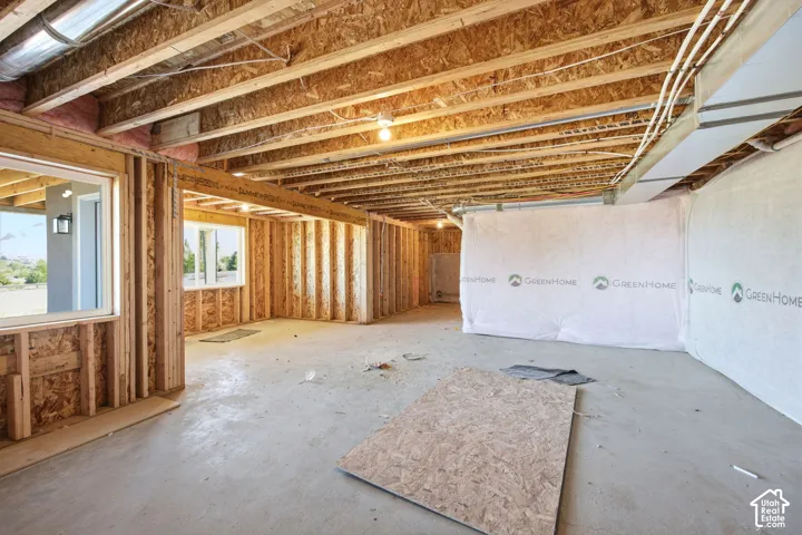 Spacious unfinished interior framing with exposed ceiling joists and concrete flooring