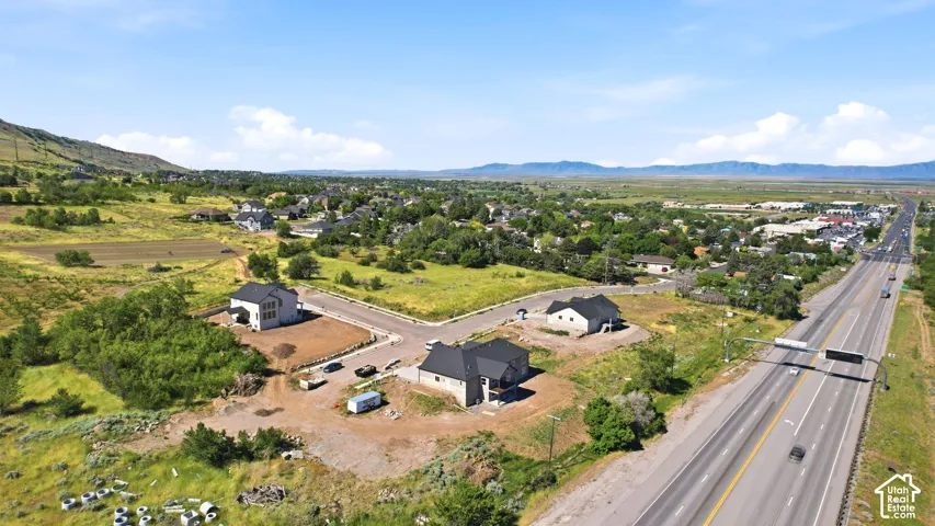 Newly constructed residential properties situated on a cul-de-sac, featuring multiple homes with dark roofing and light-colored siding