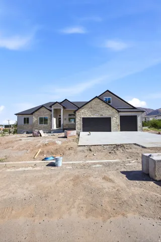 Contemporary stone and siding exterior with dark trim and a prominent two-car garage