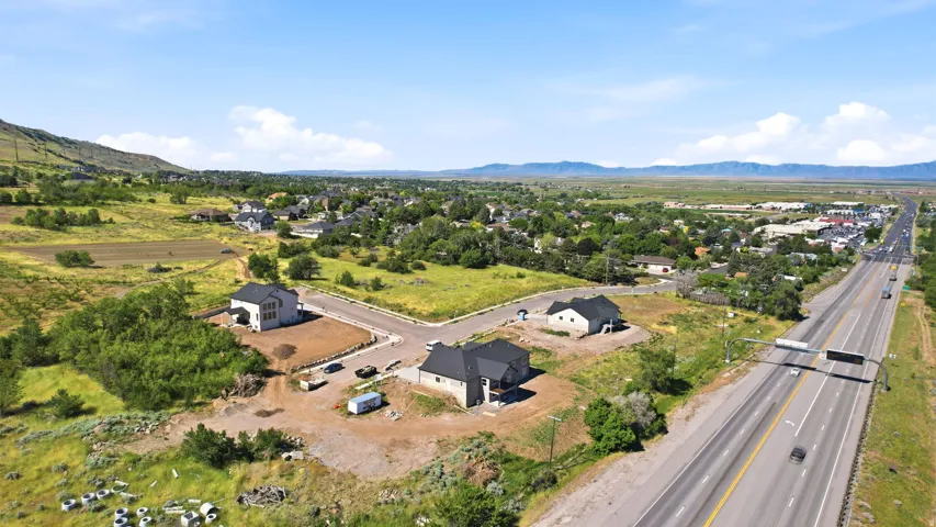 Newly constructed residential properties situated on a cul-de-sac, featuring multiple homes with dark roofing and light-colored siding