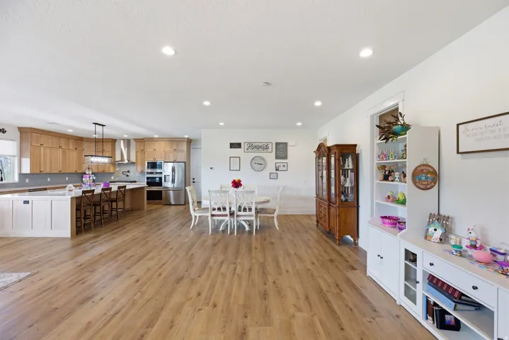 Dining area with light wood finished floors and recessed lighting