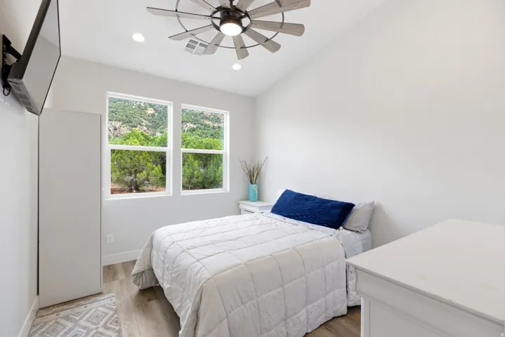 Bedroom featuring light wood-style flooring, lofted ceiling, ceiling fan, and recessed lighting