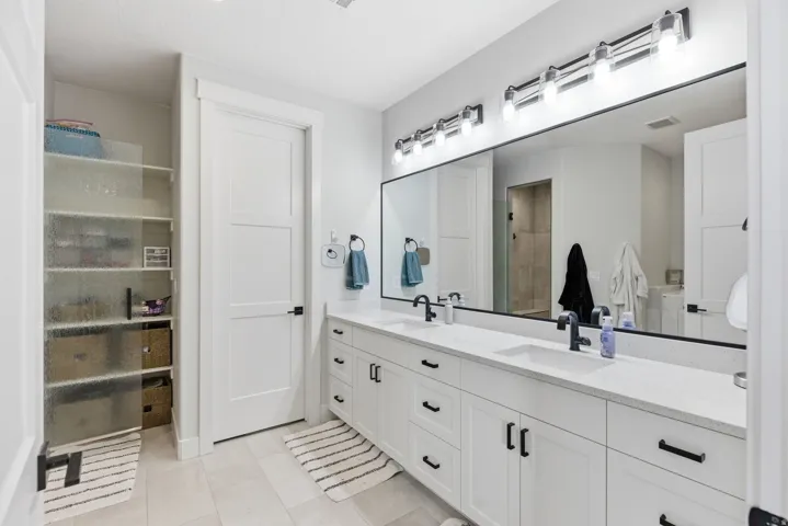 Bathroom featuring double vanity and a spacious closet