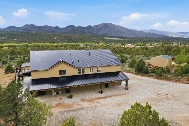 View of front of house with a mountain view, a metal roof, and stucco siding