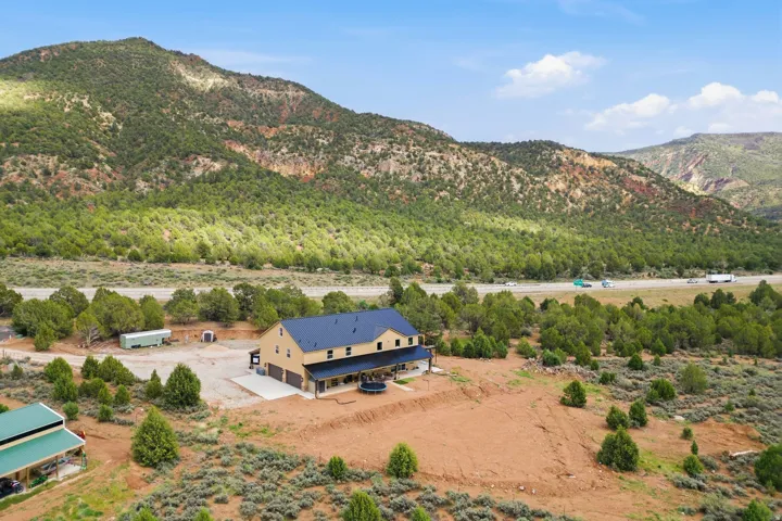 Aerial view of property and surrounding area with a mountainous background