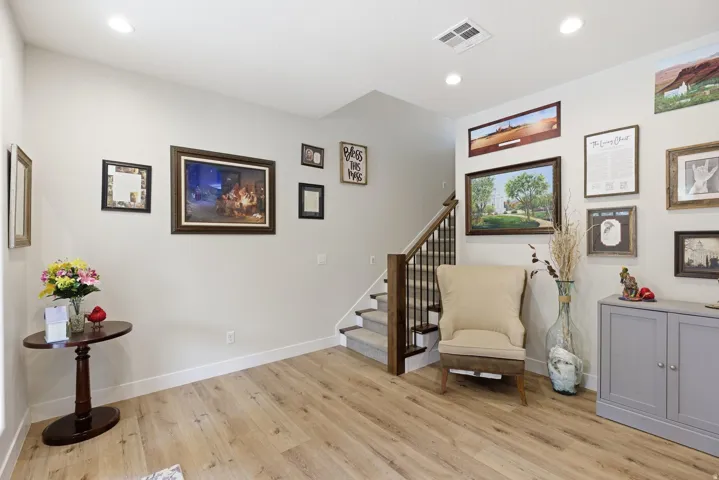 Living area with light wood-style flooring and recessed lighting