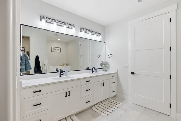 Bathroom with double vanity and light tile patterned floors