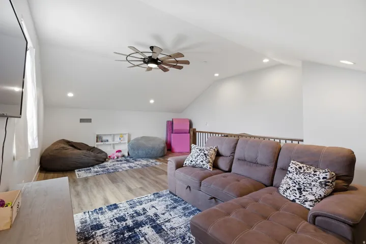 Living room with ceiling fan, wood finished floors, and recessed lighting