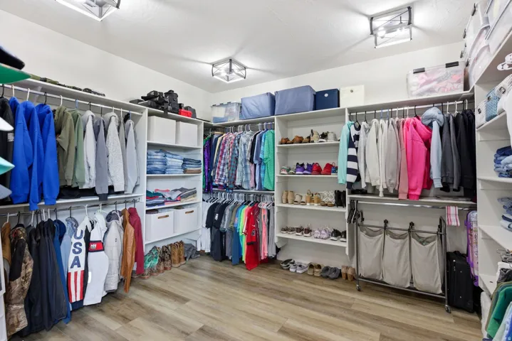Walk in closet with light wood finished floors