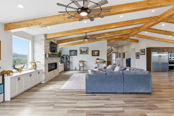 Living room featuring recessed lighting, light wood-style floors, a fireplace, lofted ceiling, and ceiling fan