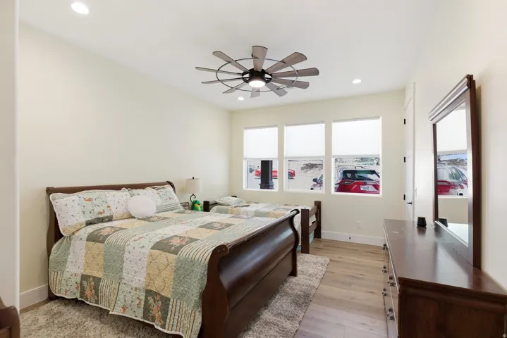 Bedroom with light wood-style flooring, ceiling fan, and recessed lighting