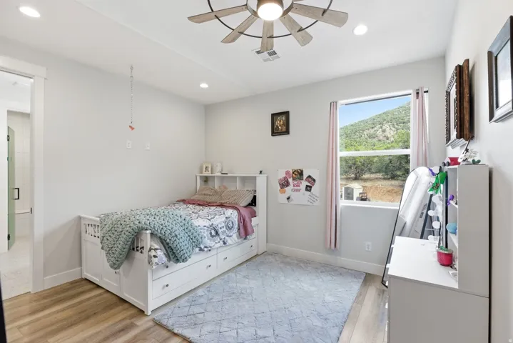 Bedroom featuring light wood-style flooring, ceiling fan, and recessed lighting