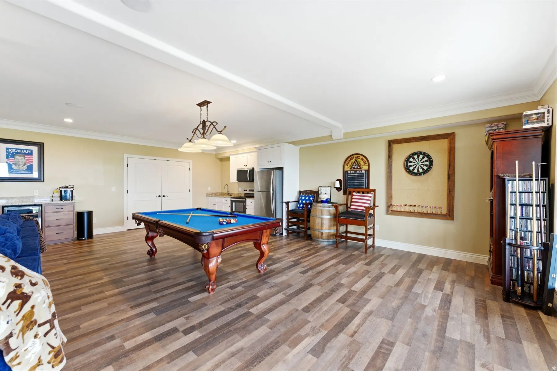 Game room featuring pool table, dark wood-type flooring, crown molding, recessed lighting, and bar