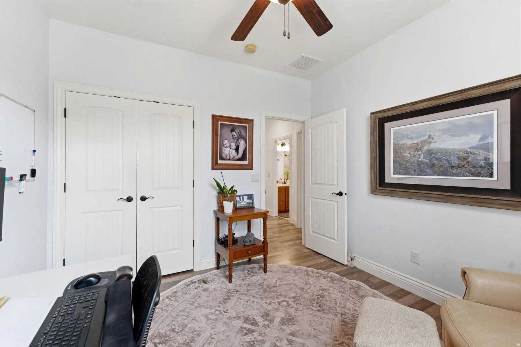 Bedroom #2/Office main floor area with light wood-style flooring and ceiling fan