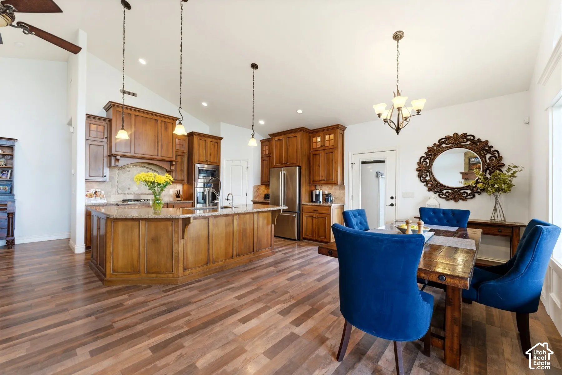 Dining area featuring a chandelier, a ceiling fan, lofted ceiling, and dark wood finished floors