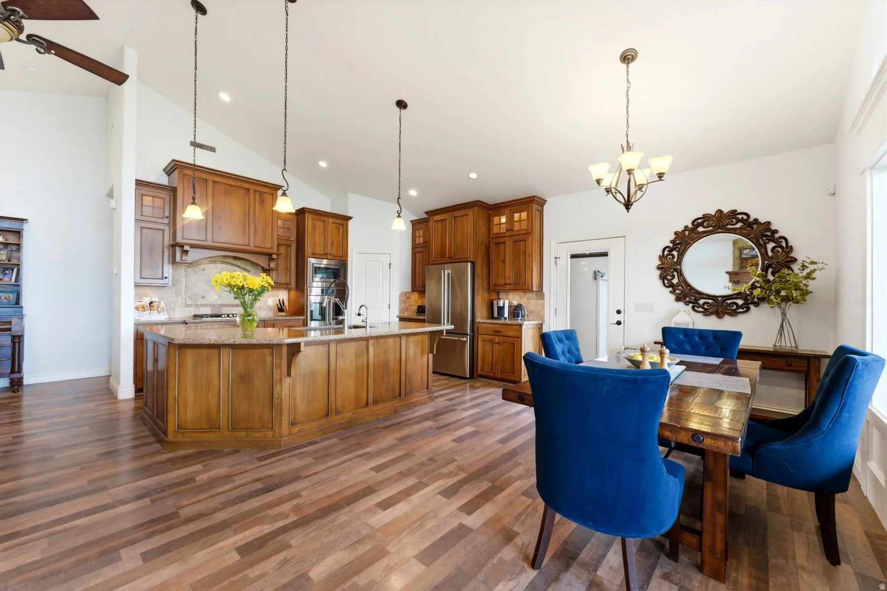 Dining area featuring a chandelier, a ceiling fan, lofted ceiling, and dark wood finished floors
