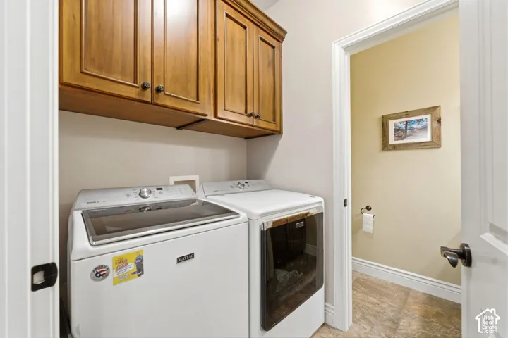 Laundry area featuring cabinet space and washer and clothes dryer