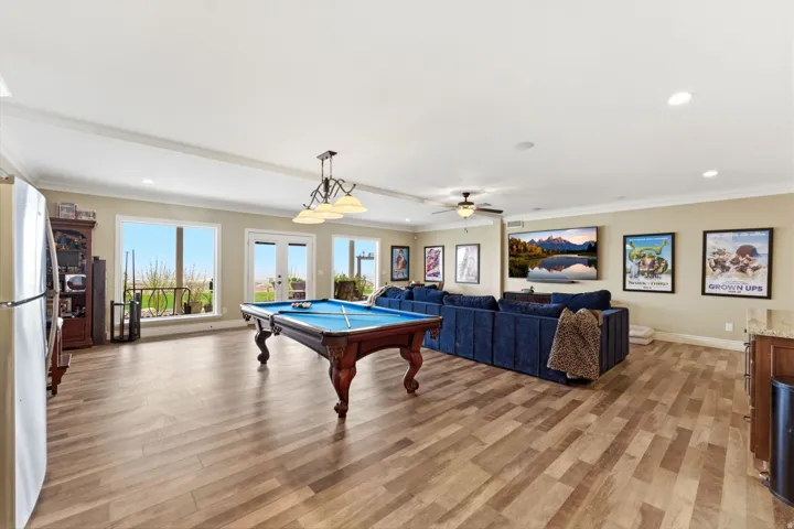 Rec room with french doors, ceiling fan, billiards, light wood finished floors, and ornamental molding
