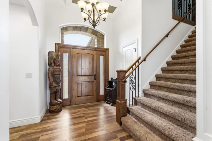 Foyer entrance featuring hardwood / wood-style floors, a chandelier, a high ceiling, and arched walkways