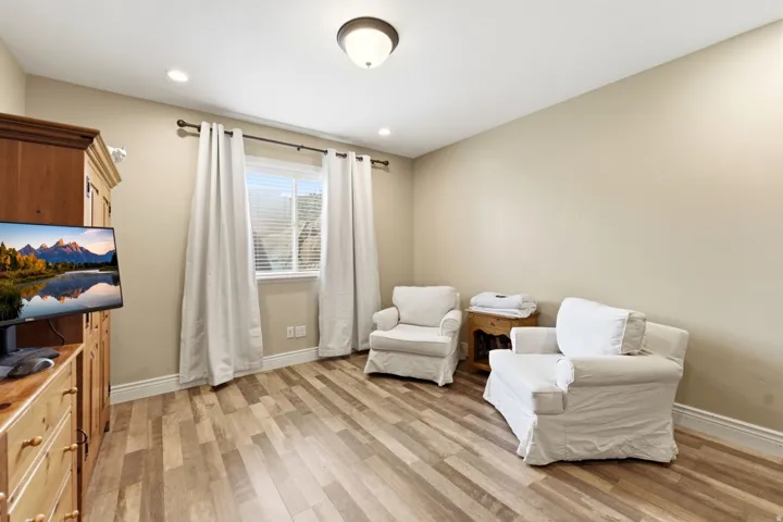 Living area with light wood-style flooring and recessed lighting