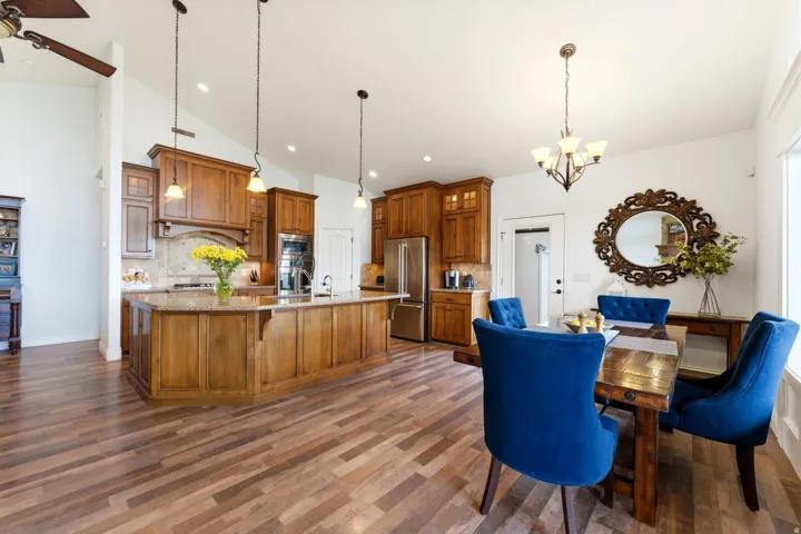 Dining area featuring a chandelier, a ceiling fan, lofted ceiling, and dark wood finished floors