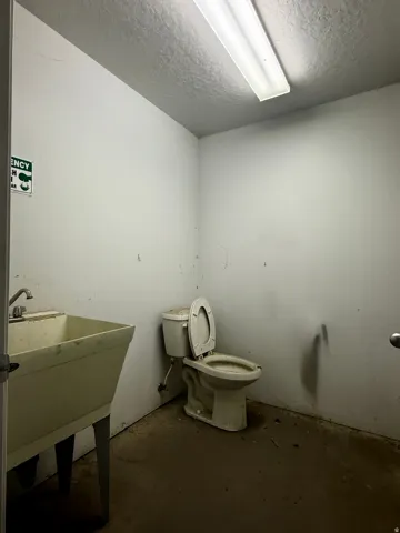 Bathroom with concrete floors and a textured ceiling