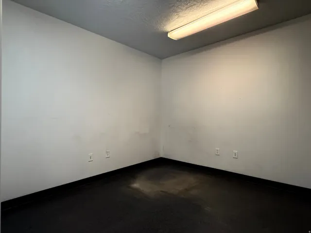 Empty room featuring finished concrete flooring and a textured ceiling