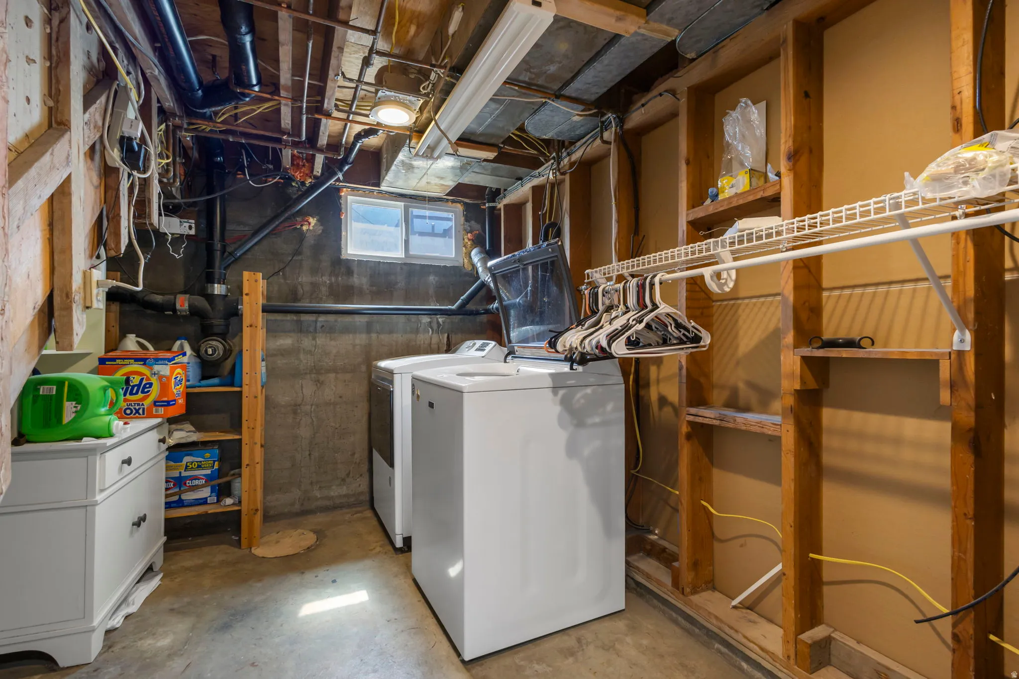 Laundry area featuring unfinished concrete flooring and separate washer and dryer
