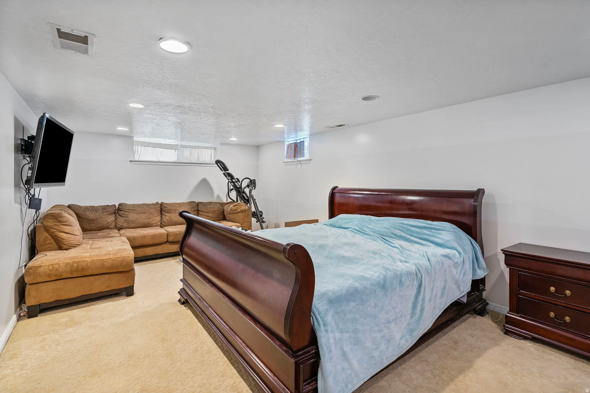 Bedroom featuring light colored carpet, a textured ceiling, and recessed lighting