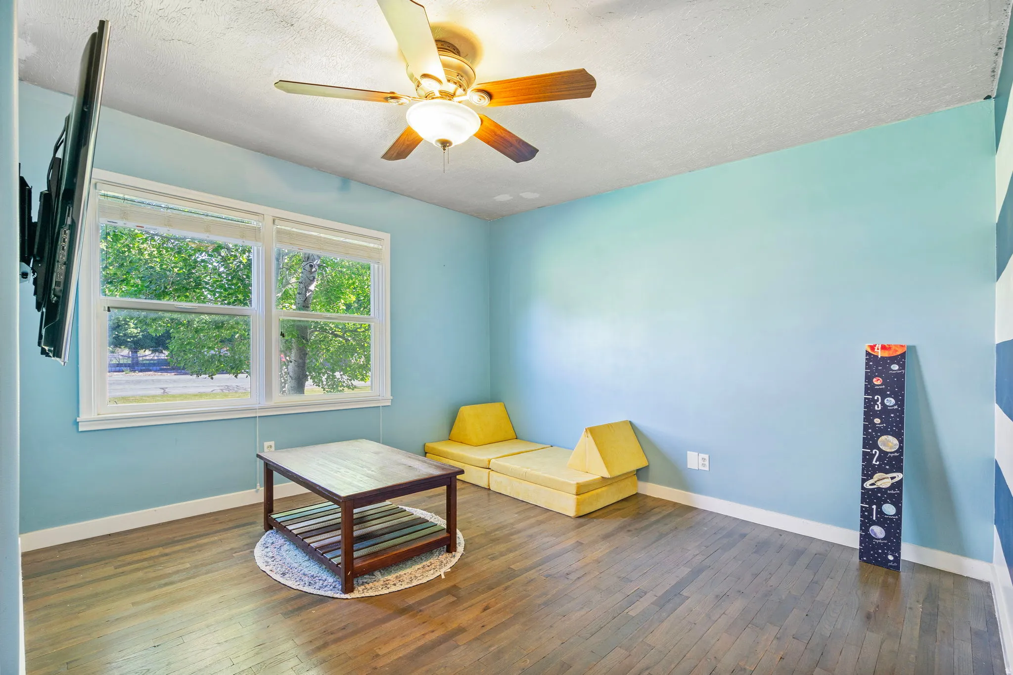 Sitting room featuring dark wood finished floors, a textured ceiling, and ceiling fan