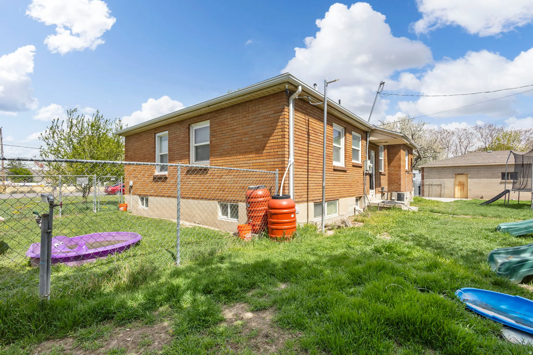 View of side of home featuring brick siding and a trampoline